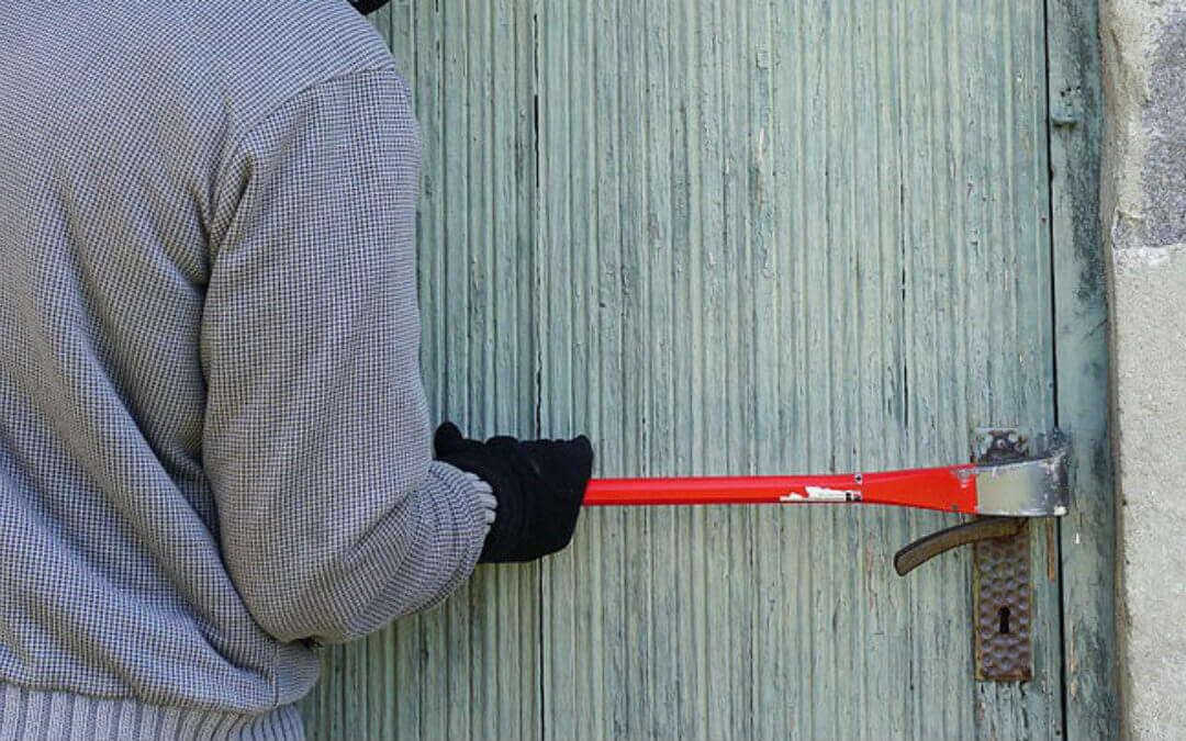 burglar breaking into a house with a crow bar