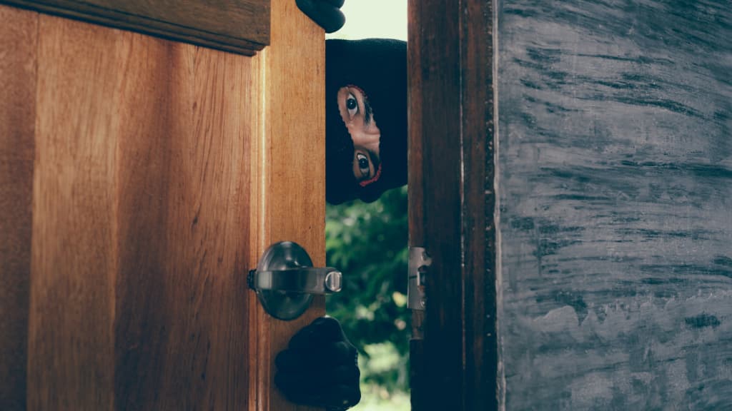 male thief appearing through door